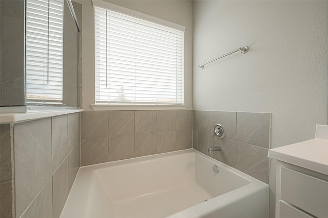 full bathroom with a bath and vanity