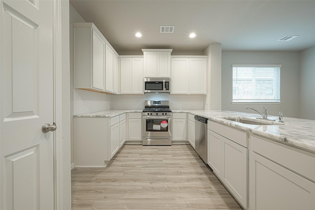 kitchen featuring light wood-style flooring, a sink, appliances with stainless steel finishes, and visible vents
