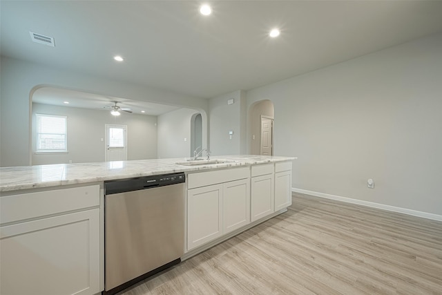 kitchen featuring white cabinetry, stainless steel dishwasher, a sink, arched walkways, and ceiling fan