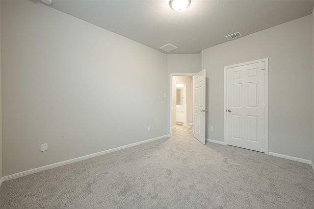 unfurnished bedroom featuring baseboards, visible vents, and carpet