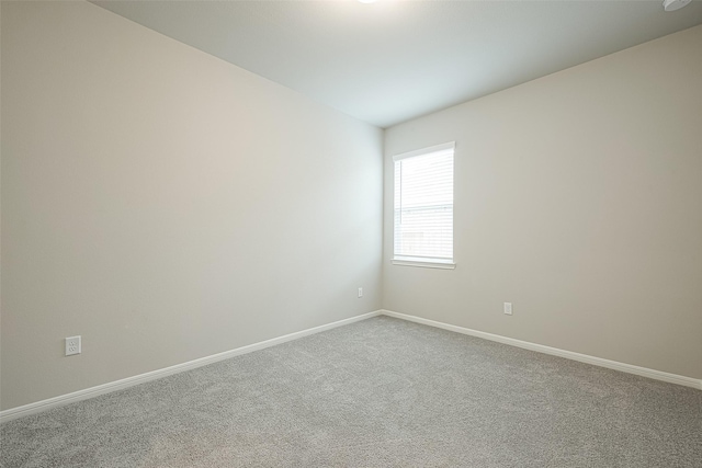 carpeted empty room featuring baseboards