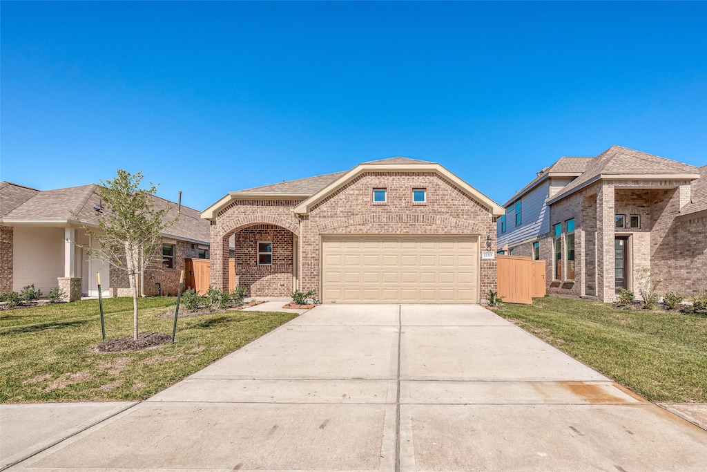 12351 Sterling Oak Dr, Humble, TX 77044 - view of front of property with driveway, brick siding, a front lawn, and an attached garage
