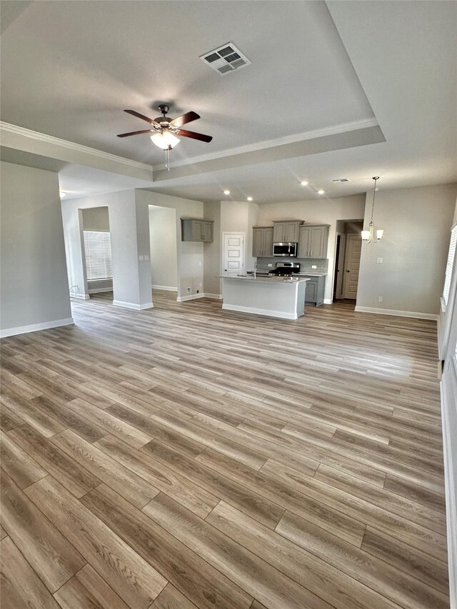 4210 Leslies Way, Dickinson, TX 77539 - unfurnished living room with baseboards, a raised ceiling, light wood finished floors, a ceiling fan, and recessed lighting