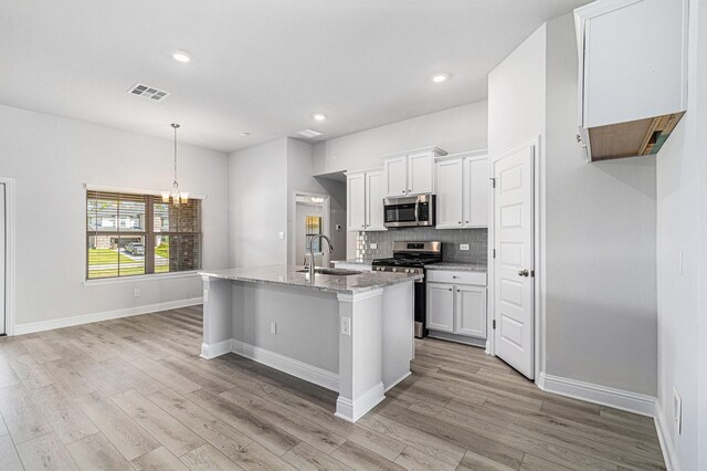 4210 Leslies Way, Dickinson, TX 77539 - kitchen with appliances with stainless steel finishes, a sink, a chandelier, backsplash, and light wood-style flooring