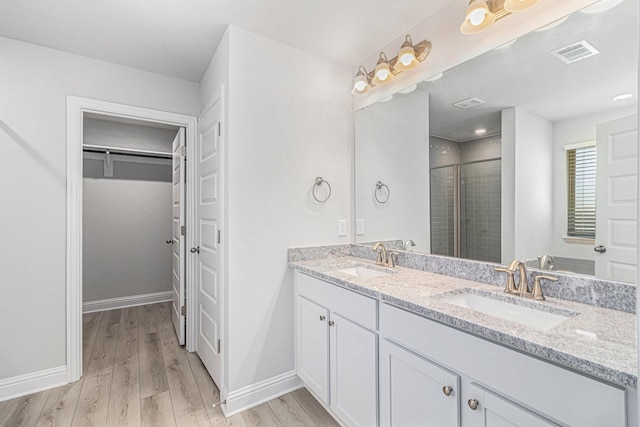 4210 Leslies Way, Dickinson, TX 77539 - full bath with a spacious closet, wood finished floors, tiled shower, baseboards, and double vanity