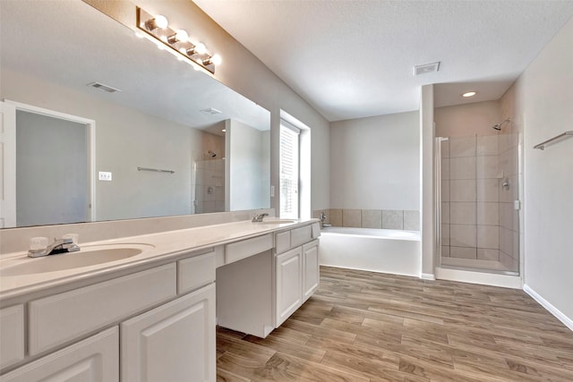 full bathroom featuring a sink, a bath, visible vents, and a shower stall