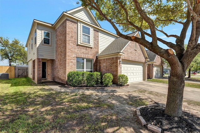 traditional home featuring fence, driveway, a garage, and brick siding