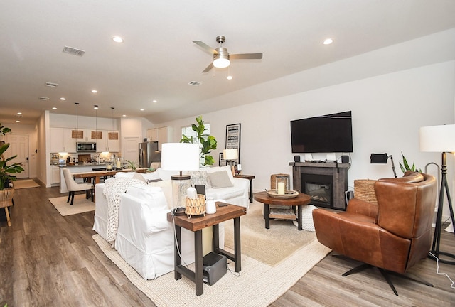 living room with a ceiling fan, light wood-style flooring, recessed lighting, and visible vents