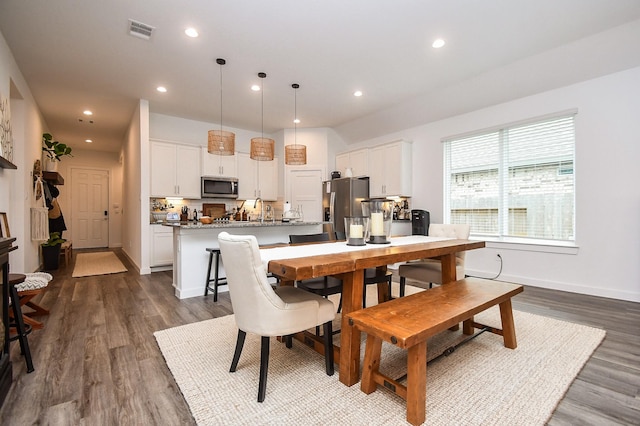 dining room featuring dark wood finished floors, recessed lighting, baseboards, and visible vents
