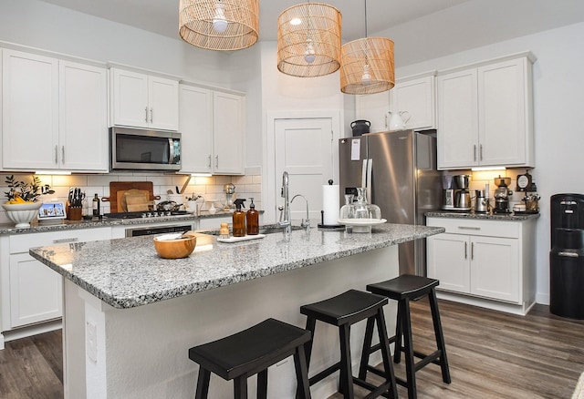 kitchen featuring white cabinetry, dark wood-style floors, stainless steel appliances, and tasteful backsplash