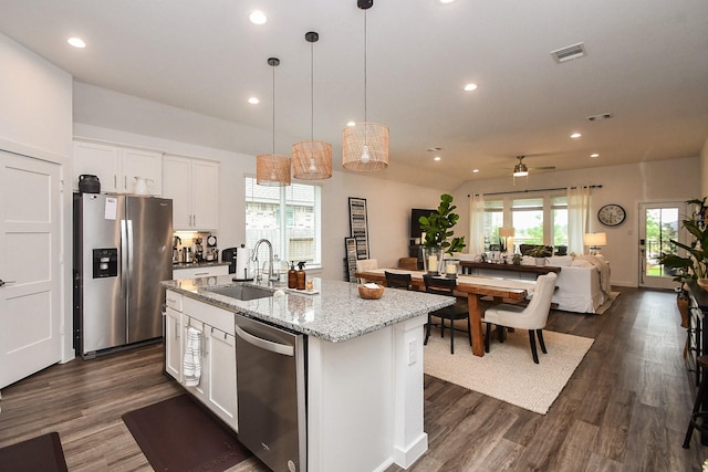 kitchen featuring visible vents, stainless steel appliances, white cabinetry, a sink, and an island with sink
