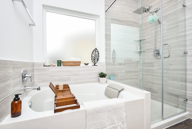 full bathroom featuring a garden tub and a stall shower