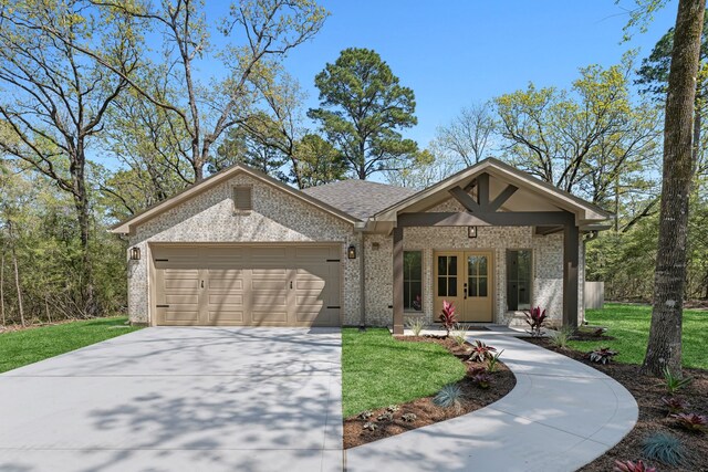20302 Peach Dr, Huntsville, TX 77320 - view of front of property with brick siding, a garage, driveway, and a front lawn