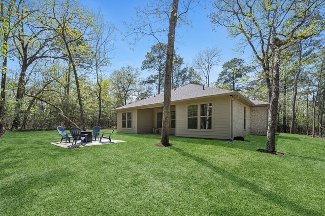 20302 Peach Dr, Huntsville, TX 77320 - back of house featuring a lawn, a fire pit, and a patio area