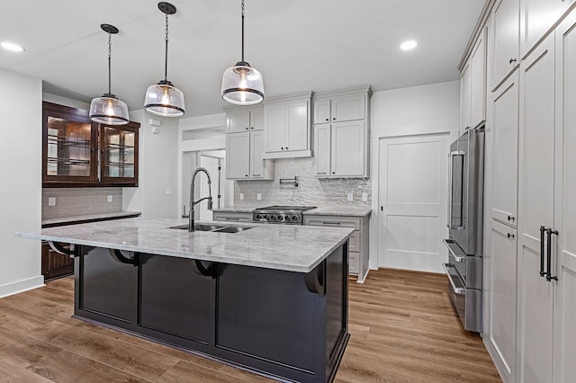 20302 Peach Dr, Huntsville, TX 77320 - kitchen featuring high end refrigerator, backsplash, a sink, stove, and wood finished floors