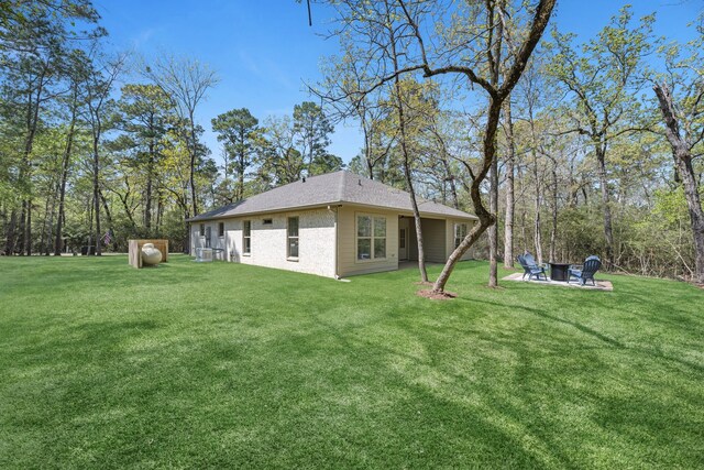 20302 Peach Dr, Huntsville, TX 77320 - back of house featuring a yard and a fire pit