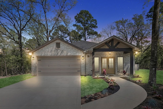 20302 Peach Dr, Huntsville, TX 77320 - view of front of house with a garage, driveway, french doors, a front yard, and brick siding