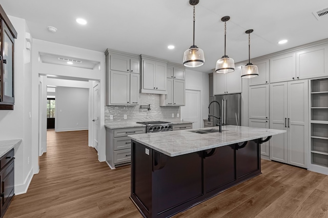 20302 Peach Dr, Huntsville, TX 77320 - kitchen featuring high quality fridge, a sink, baseboards, backsplash, and light stone counters
