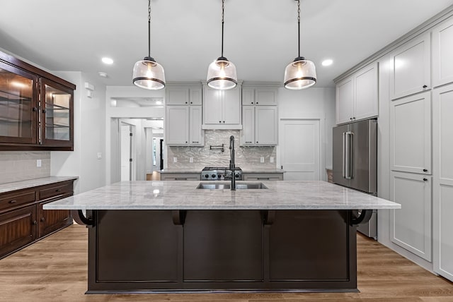 20302 Peach Dr, Huntsville, TX 77320 - kitchen featuring high end fridge, backsplash, a breakfast bar area, light stone countertops, and recessed lighting