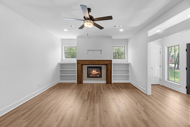 20302 Peach Dr, Huntsville, TX 77320 - unfurnished living room with baseboards, light wood-type flooring, a glass covered fireplace, healthy amount of natural light, and recessed lighting