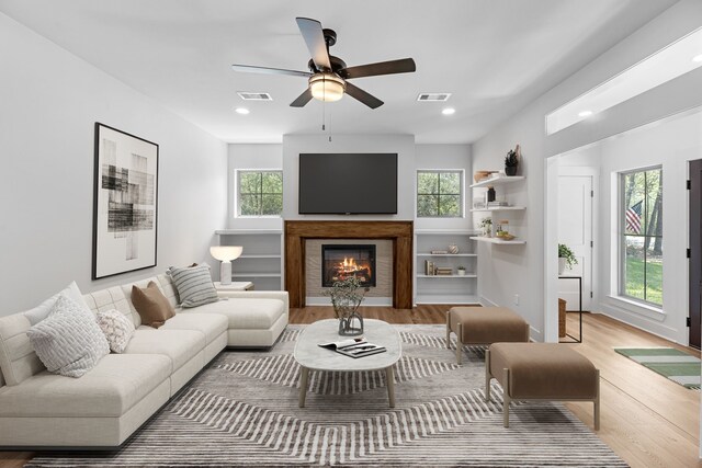 20302 Peach Dr, Huntsville, TX 77320 - living area with light wood-type flooring, healthy amount of natural light, a lit fireplace, and recessed lighting