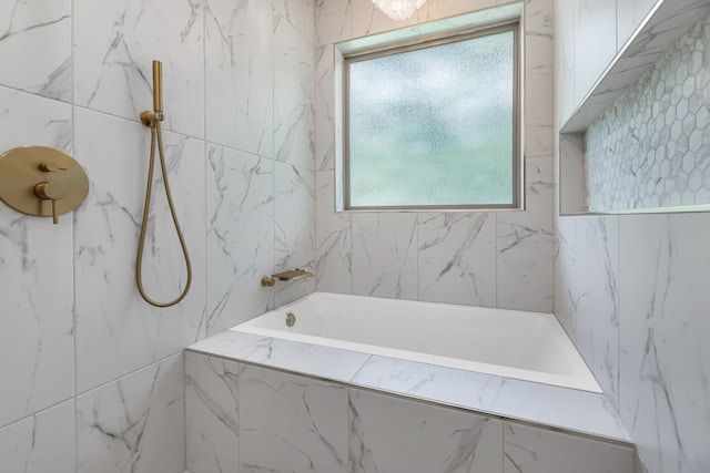 20302 Peach Dr, Huntsville, TX 77320 - bathroom featuring a tub with marble appearance, healthy amount of natural light, and a marble finish shower
