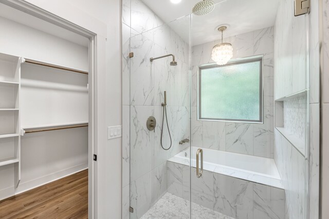 20302 Peach Dr, Huntsville, TX 77320 - full bath featuring a marble finish shower, a walk in closet, wood finished floors, and a chandelier