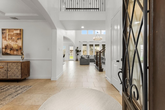 24606 Bennetts Ridge Ln, Porter, TX 77365 - entryway featuring arched walkways, a high ceiling, light tile patterned floors, baseboards, and a chandelier