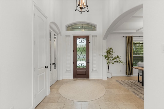 24606 Bennetts Ridge Ln, Porter, TX 77365 - foyer entrance with arched walkways, a chandelier, light tile patterned floors, and baseboards