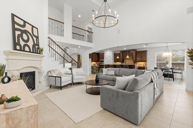 24606 Bennetts Ridge Ln, Porter, TX 77365 - living area featuring a chandelier, a fireplace, a towering ceiling, recessed lighting, and arched walkways