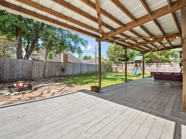 902 Rolling Mill Dr, Sugar Land, TX 77498 - wooden deck featuring a lawn, a fire pit, a fenced backyard, and a playground
