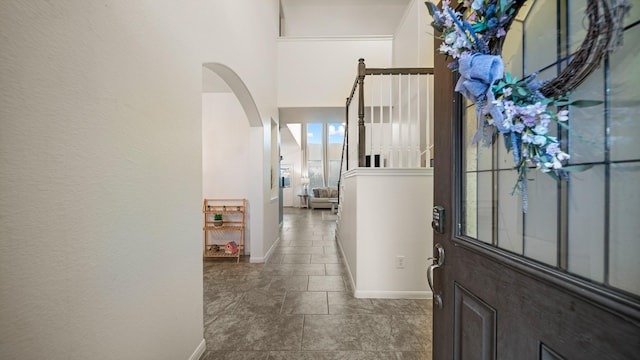 entryway with arched walkways and baseboards