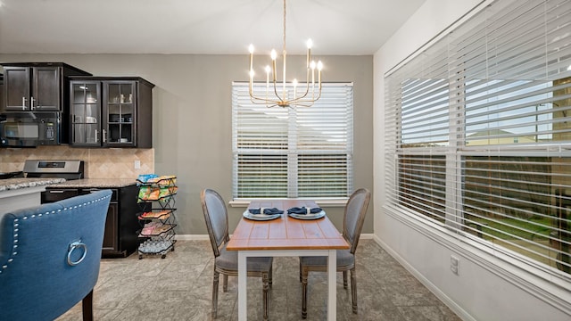 dining room with an inviting chandelier and baseboards