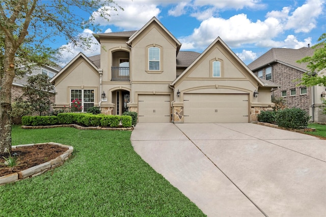 view of front of house with stucco siding, a front yard, stone siding, a balcony, and concrete driveway
