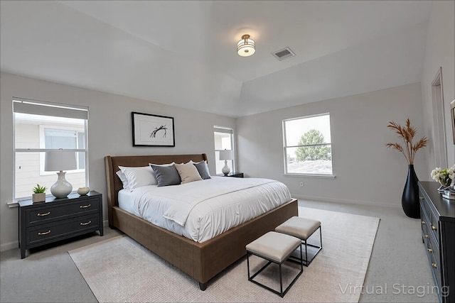 bedroom featuring light colored carpet, baseboards, vaulted ceiling, and visible vents