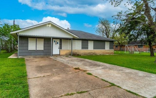 ranch-style house featuring a front yard and concrete driveway