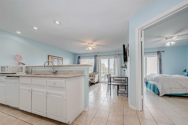 9520 Seawall Blvd Unit 126, Galveston, TX 77554 - kitchen with ceiling fan, light tile patterned floors, white appliances, white cabinets, and a sink