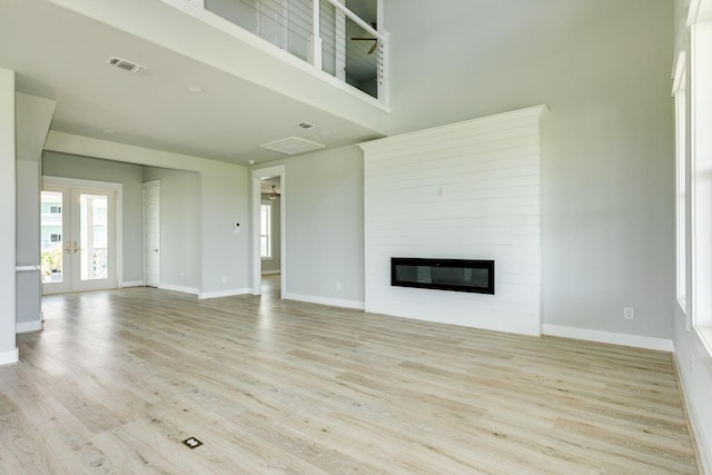 18821 Warrior Rd, Galveston, TX 77554 - unfurnished living room with wood finished floors, baseboards, a large fireplace, and a high ceiling