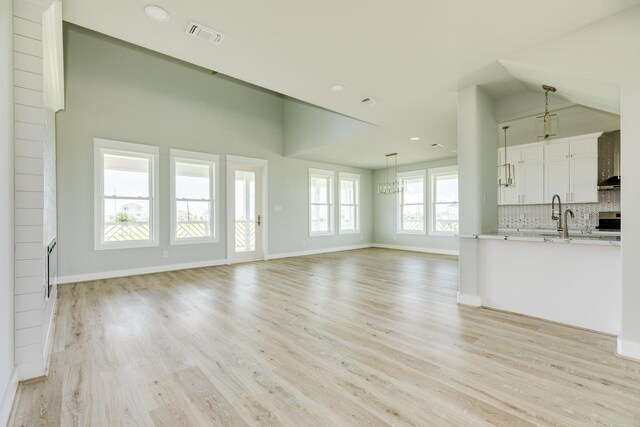 18821 Warrior Rd, Galveston, TX 77554 - unfurnished living room with light wood-style floors, baseboards, a sink, and recessed lighting