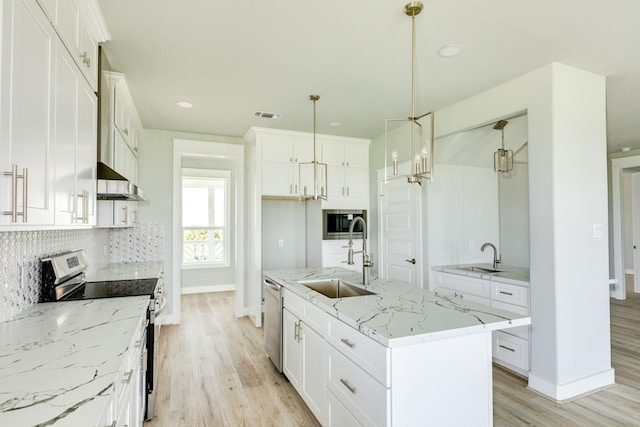 18821 Warrior Rd, Galveston, TX 77554 - kitchen featuring appliances with stainless steel finishes, a sink, baseboards, light wood-style flooring, and tasteful backsplash