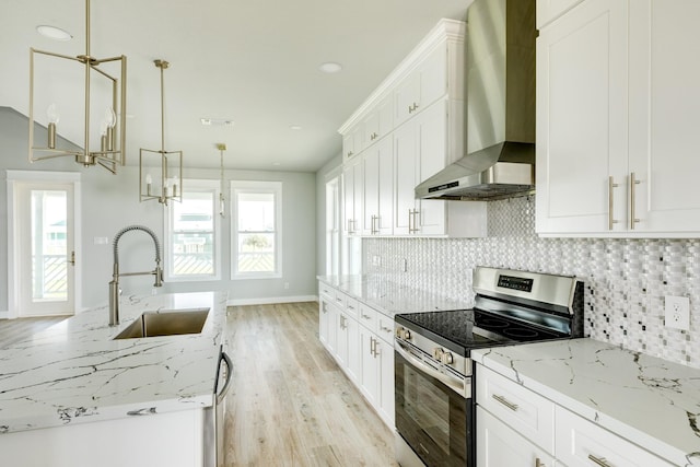 18821 Warrior Rd, Galveston, TX 77554 - kitchen with stainless steel electric range, wall chimney exhaust hood, a sink, backsplash, and light wood-style floors