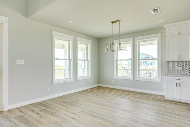 18821 Warrior Rd, Galveston, TX 77554 - unfurnished dining area with a chandelier, light wood-type flooring, baseboards, and recessed lighting