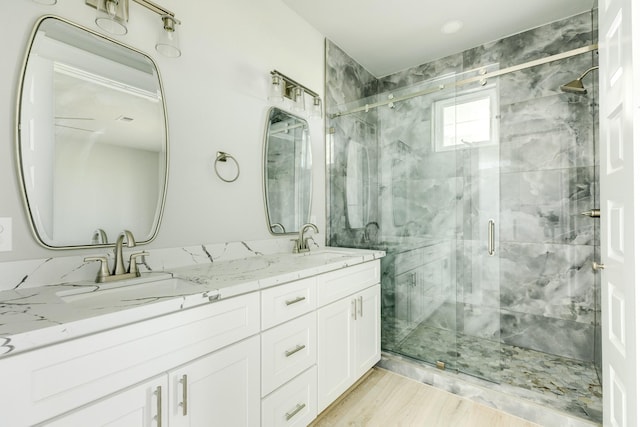 18821 Warrior Rd, Galveston, TX 77554 - bathroom with a shower stall, double vanity, and wood finished floors