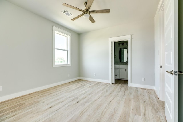 18821 Warrior Rd, Galveston, TX 77554 - unfurnished bedroom featuring light wood-style floors, baseboards, ensuite bathroom, and a ceiling fan