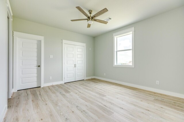 18821 Warrior Rd, Galveston, TX 77554 - unfurnished bedroom with light wood-style flooring, baseboards, a closet, and a ceiling fan