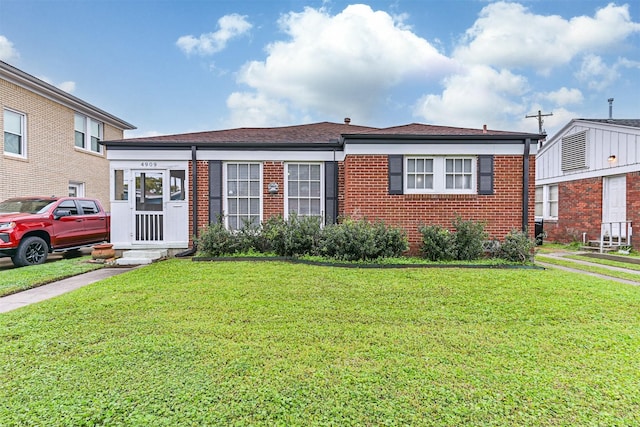 view of front of property featuring brick siding and a front lawn