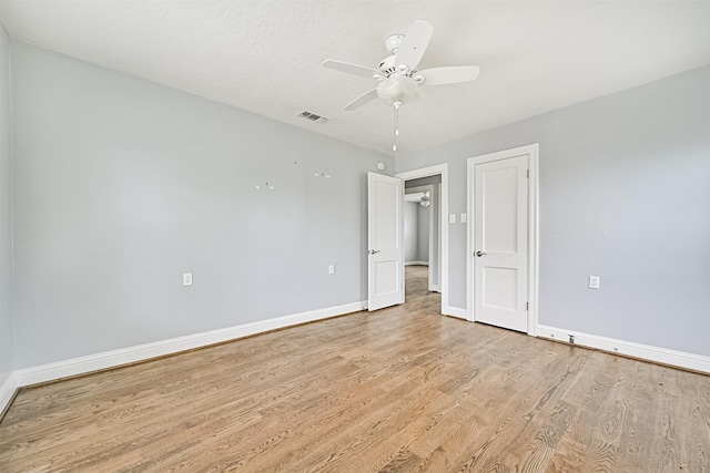 unfurnished bedroom featuring a ceiling fan, baseboards, light wood finished floors, and visible vents