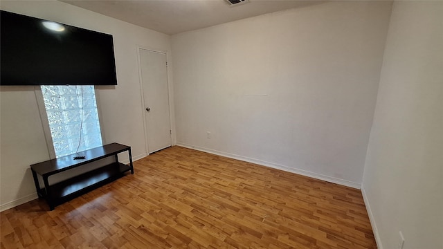 spare room featuring baseboards, visible vents, and light wood-style floors