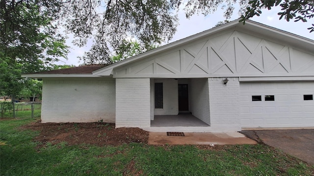 exterior space with fence, an attached garage, and brick siding
