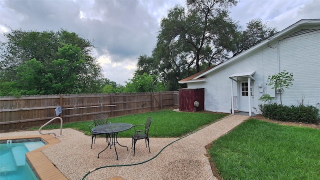 view of yard with fence, a fenced in pool, and a patio area